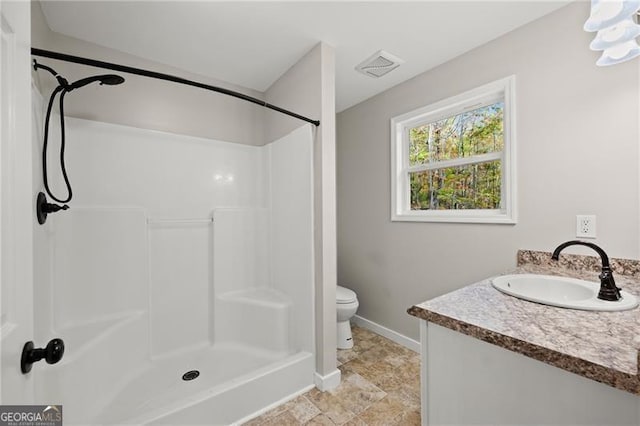 bathroom with baseboards, visible vents, toilet, and walk in shower