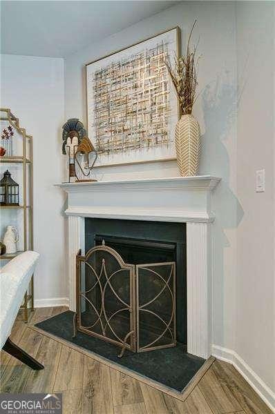 interior details featuring a fireplace, baseboards, and wood finished floors