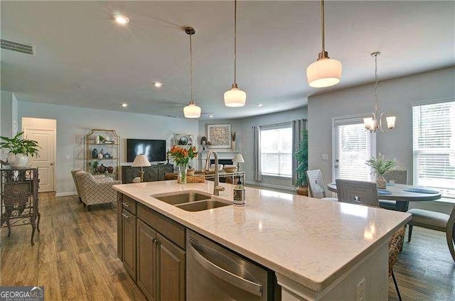 kitchen featuring dark wood-style floors, pendant lighting, open floor plan, a sink, and dishwasher