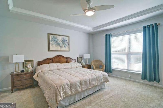 carpeted bedroom with ceiling fan, a tray ceiling, and baseboards