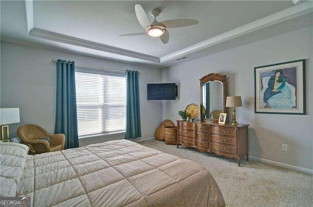 carpeted bedroom featuring visible vents, a tray ceiling, a ceiling fan, and baseboards