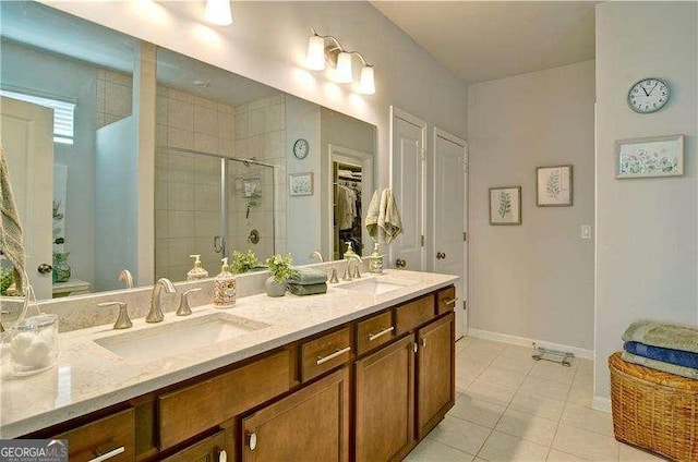 bathroom featuring double vanity, tile patterned floors, a sink, and a shower stall