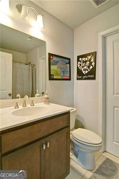 full bath with visible vents, vanity, toilet, and tile patterned floors