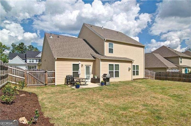 rear view of house with a patio area, a fenced backyard, a gate, and a lawn