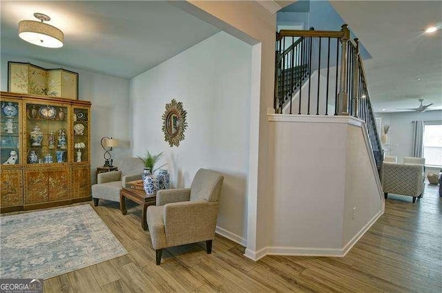 living area featuring stairway, baseboards, and wood finished floors