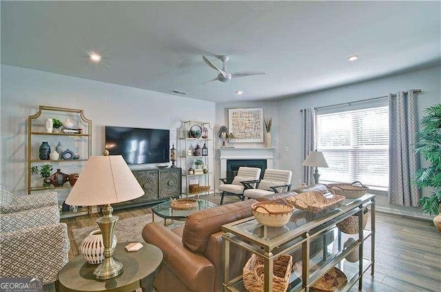 living area with a fireplace, a ceiling fan, wood finished floors, and recessed lighting