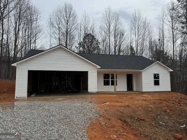 ranch-style home featuring a garage and a shingled roof