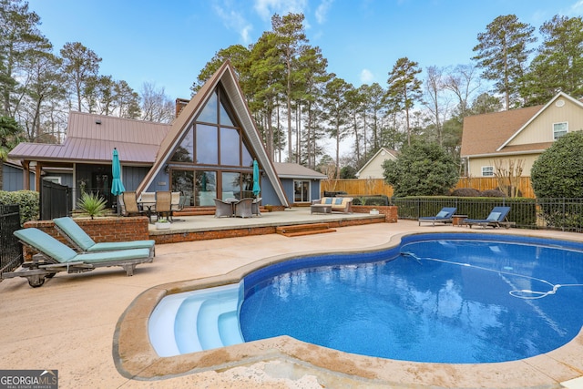 view of swimming pool featuring a patio area, fence, and a fenced in pool