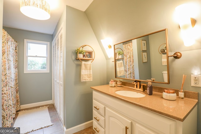 full bath with tile patterned flooring, vanity, and baseboards
