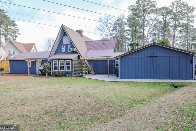 back of property with metal roof, a patio, a lawn, and a chimney