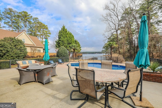106 Honeysuckle Ln NE, Milledgeville, GA 31061 - fenced backyard with a patio, outdoor dining space, and a water view