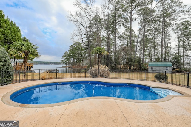 view of swimming pool with a fenced in pool, a patio area, a water view, and fence