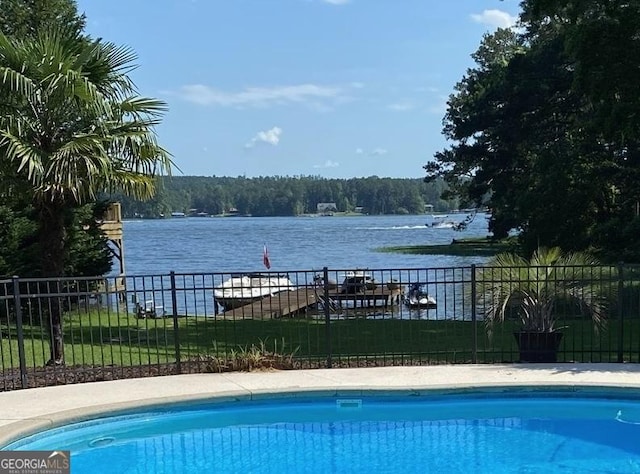 view of pool with a water view, fence, and a fenced in pool