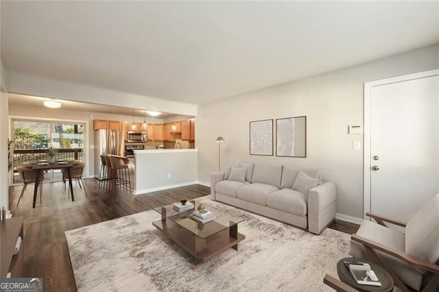 living area featuring dark wood-type flooring and baseboards