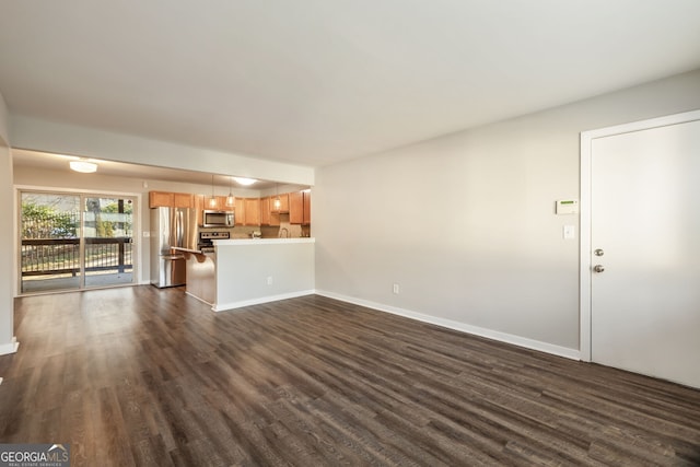 unfurnished living room with dark wood-style flooring and baseboards