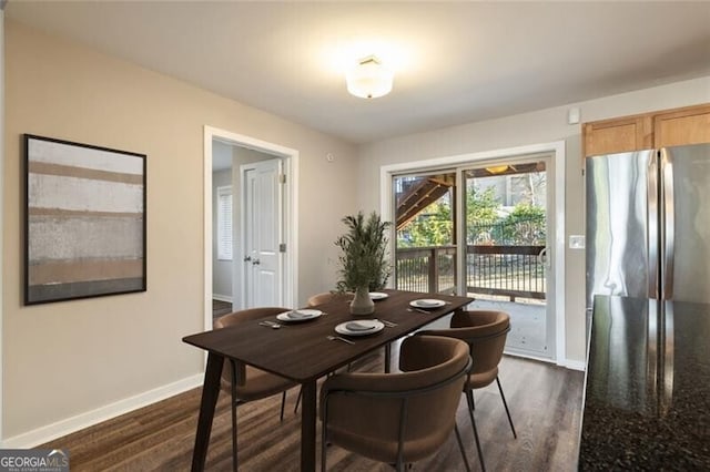 dining room featuring dark wood finished floors and baseboards