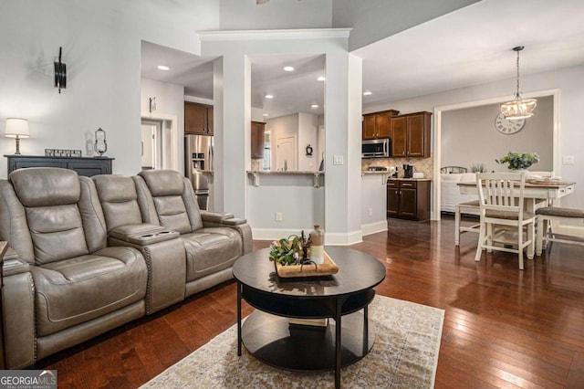 living area featuring a notable chandelier, baseboards, dark wood-type flooring, and recessed lighting