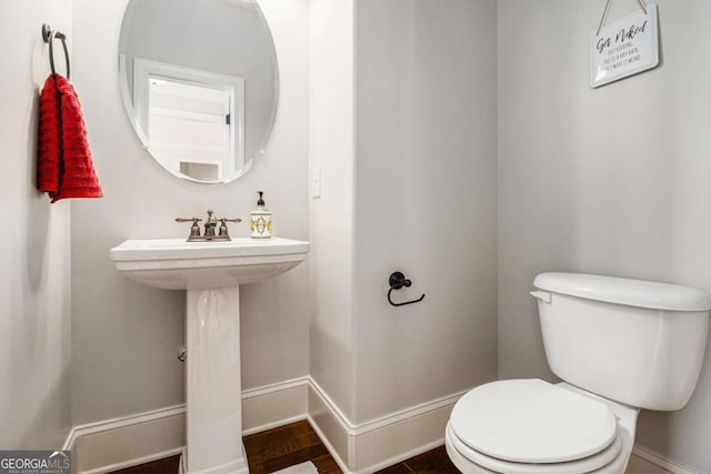 bathroom featuring toilet and baseboards