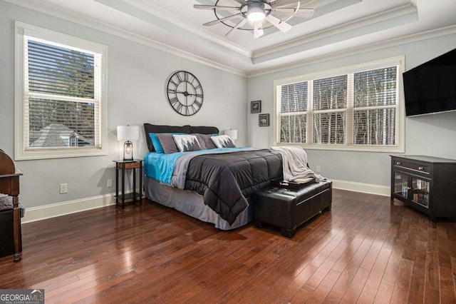 bedroom with crown molding, a raised ceiling, and hardwood / wood-style floors