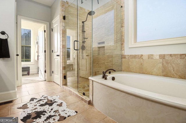 bathroom with a stall shower, baseboards, visible vents, tile patterned floors, and a bath