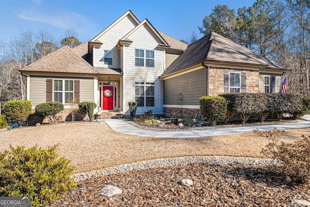 craftsman-style house with stone siding and a shingled roof