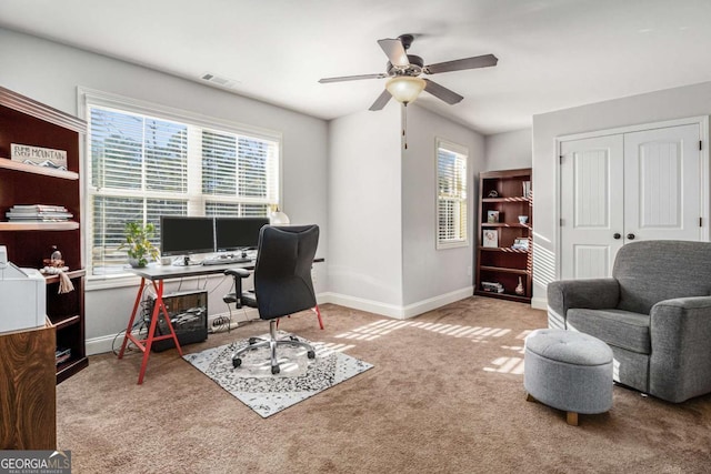 office area featuring carpet floors, a ceiling fan, visible vents, and baseboards