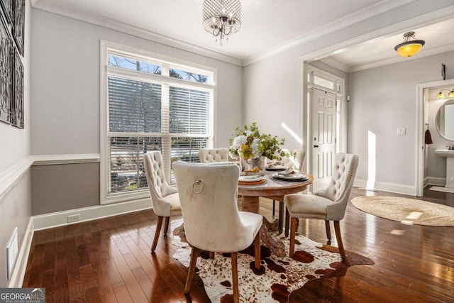 dining space with baseboards, wood-type flooring, and crown molding