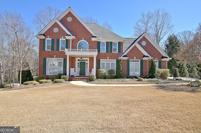 view of front of house with a balcony and brick siding