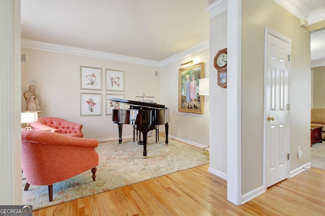 sitting room with ornamental molding, visible vents, baseboards, and wood finished floors