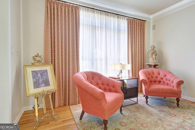 living area featuring ornamental molding, wood finished floors, and baseboards