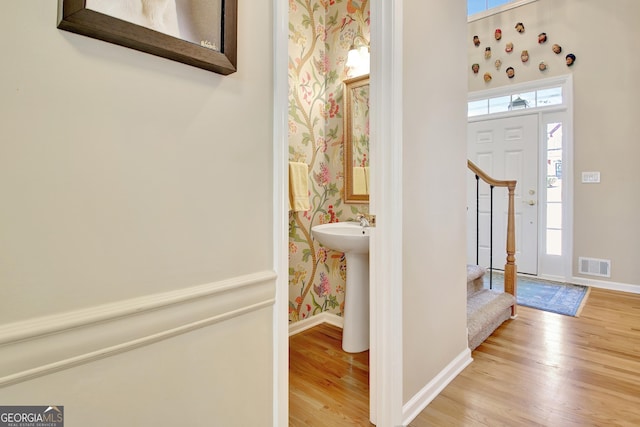 foyer entrance with plenty of natural light, wood finished floors, and visible vents