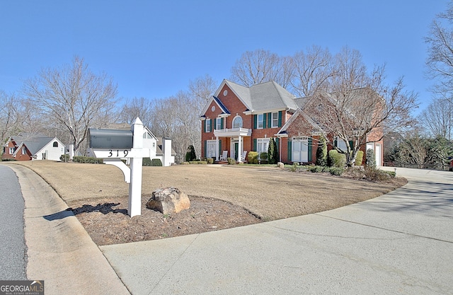 view of front of home featuring driveway, brick siding, and a residential view