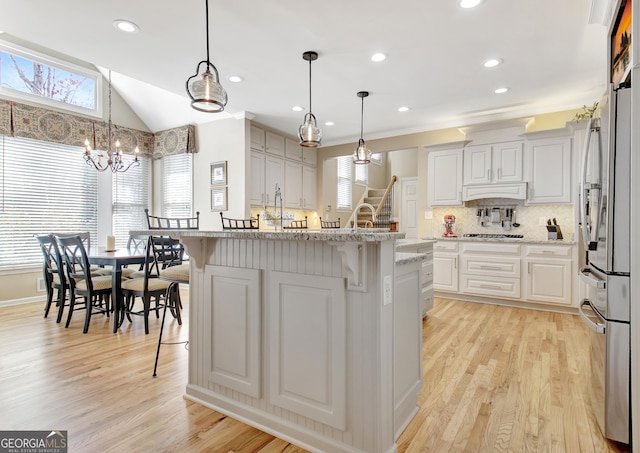 kitchen with tasteful backsplash, a kitchen bar, and light wood-style flooring