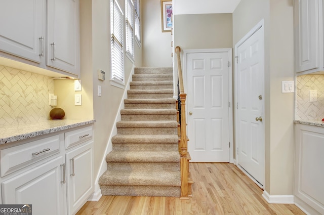 staircase featuring baseboards and wood finished floors