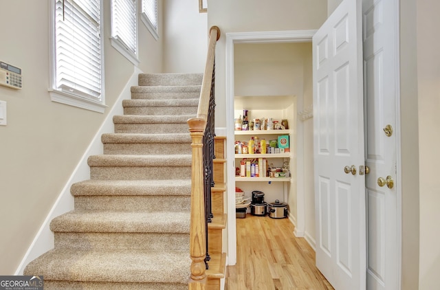 staircase with wood finished floors and baseboards