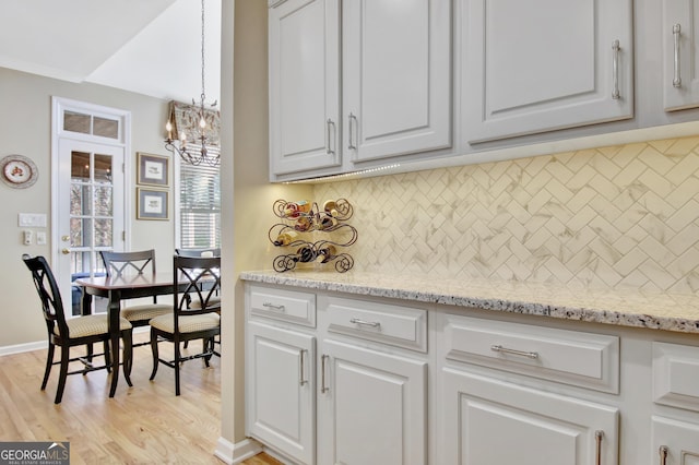 kitchen featuring light wood-style floors, white cabinets, and decorative backsplash