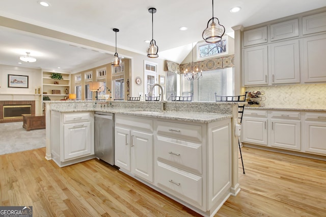 kitchen with open floor plan, a fireplace, a sink, and light wood-style flooring