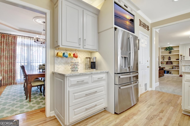 kitchen featuring light wood finished floors, ornamental molding, and white cabinets