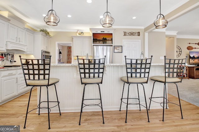 kitchen with white cabinetry, light wood-style flooring, appliances with stainless steel finishes, and crown molding