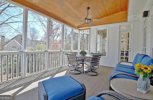 sunroom featuring vaulted ceiling, ceiling fan, a wealth of natural light, and wood ceiling