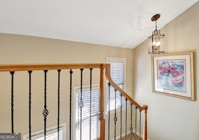 stairs featuring lofted ceiling and a chandelier