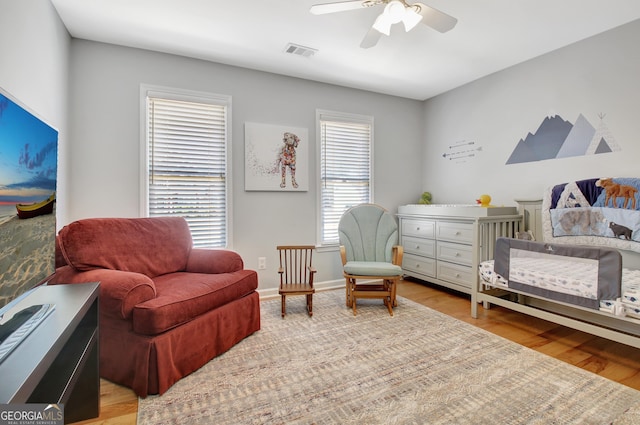 bedroom featuring light wood-type flooring, baseboards, visible vents, and a ceiling fan