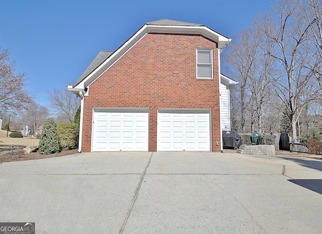 view of home's exterior featuring brick siding and driveway