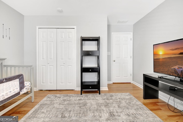 bedroom featuring a closet, wood finished floors, and baseboards