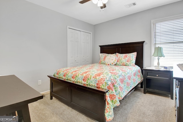 bedroom with light carpet, a ceiling fan, visible vents, baseboards, and a closet