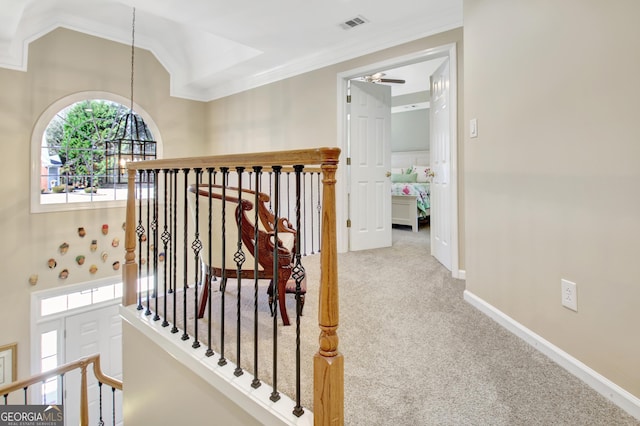 hall featuring baseboards, lofted ceiling, ornamental molding, an upstairs landing, and carpet floors