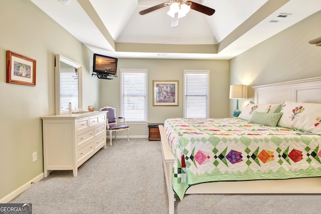 bedroom featuring baseboards, a raised ceiling, a ceiling fan, and light colored carpet