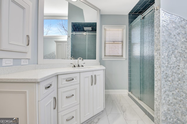 bathroom with marble finish floor, a shower stall, baseboards, and vanity