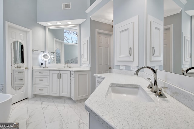 bathroom featuring marble finish floor, visible vents, ornamental molding, and a sink