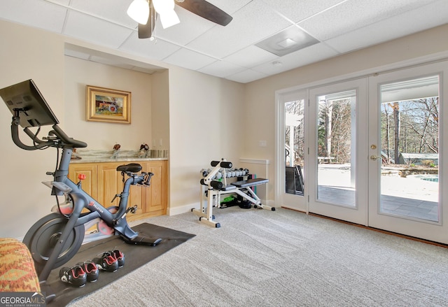 workout area with light carpet, french doors, a paneled ceiling, and baseboards